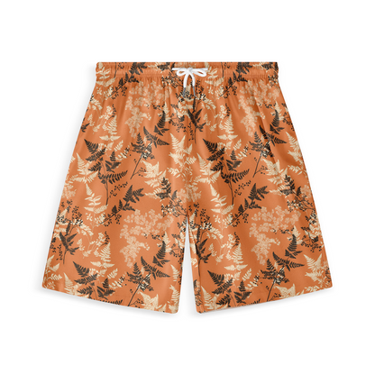 A pair of shorts featuring delicate black and light-colored fern patterns on an orange background, offering a nature-inspired design with an autumnal feel.