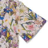 Detail of a floral pattern showcasing lilies and irises on a stylish shirt.