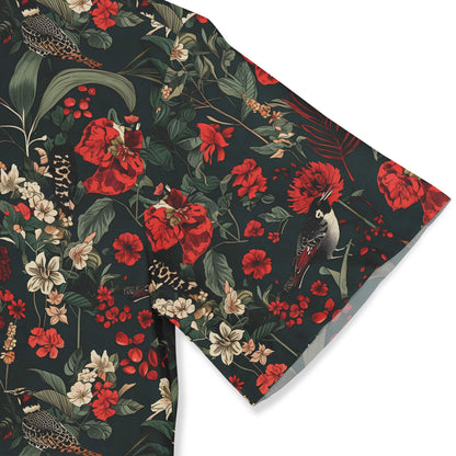 Close-up of a patterned shirt showcasing red and white flowers with birds, set against a dark background.