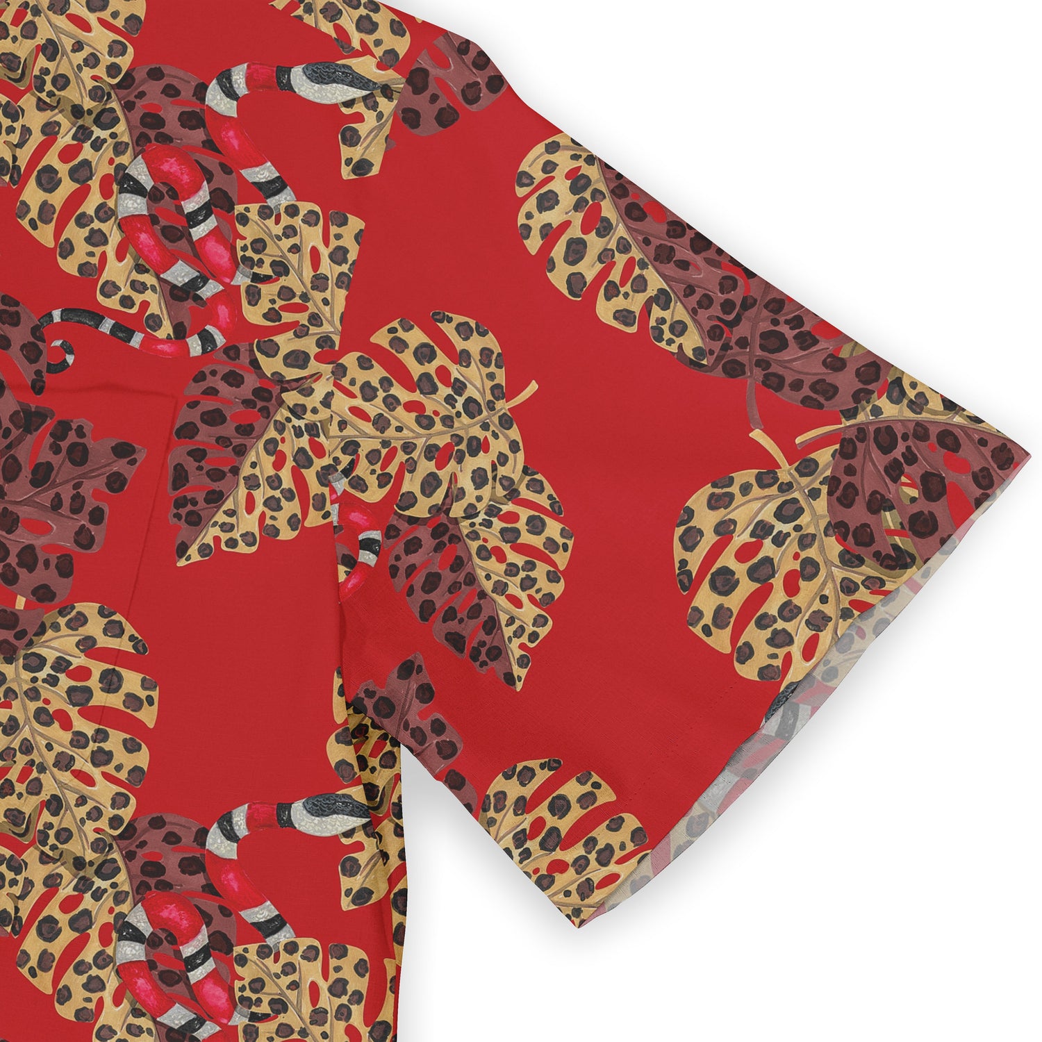 Close-up of a Hawaiian shirt sleeve featuring a vibrant red background, decorated with large leopard-print leaves in yellow, brown, and black tones, and a subtle snake design.