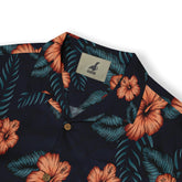 Close-up of a shirt collar with a pattern of orange hibiscus flowers and green leaves on a dark background, featuring a visible "Kalvero" label.