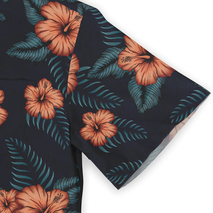 A shirt sleeve with a pattern of orange hibiscus flowers and green leaves on a dark background.