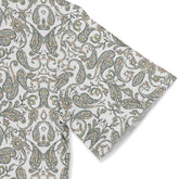 A short-sleeved shirt with a "Serenity Scrolls" pattern, featuring blue and white paisley motifs and floral vines framed by geometric borders sleeve close-up