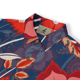 This is a Hawaiian shirt featuring a vibrant tropical floral pattern in red, purple, and blue tones. The design includes large flowers and leaves with brown buttons, highlighting a lively tropical vibe.