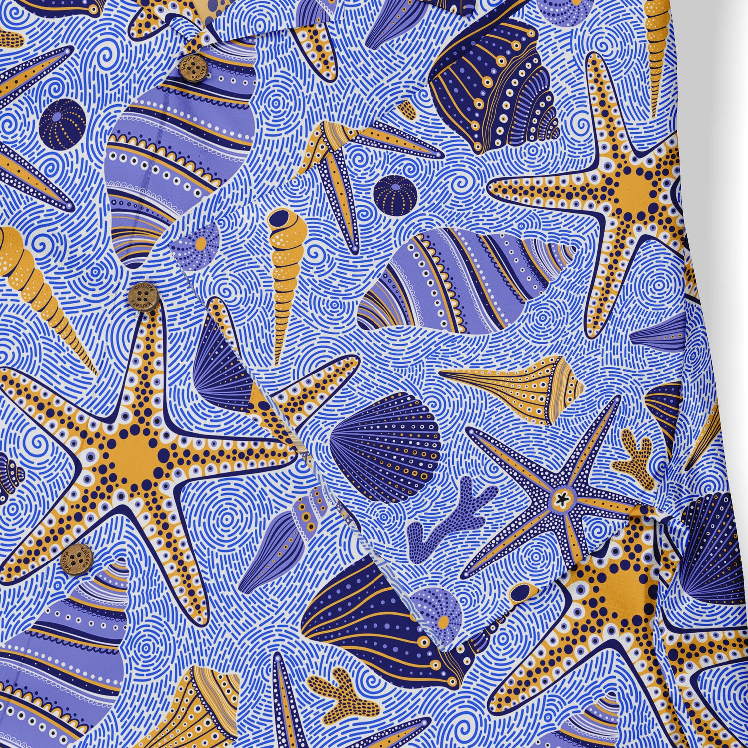 Blue and gold seashells and starfish design on a Hawaiian shirt, close-up view