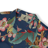 Close-up of a shirt collar showcasing a vibrant floral and leaf pattern in rich colors on a dark blue background.